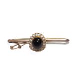 A cabochon garnet and diamond cluster bar brooch