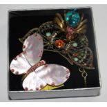 A bag with a pendant necklace in the form of a gem set butterfly together with two insect brooches