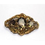 A gold colour metal brooch set with three smoky quartz stones