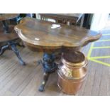 A mid Victorian rosewood foldover card table, the shaped top and frieze over a cabochon carved