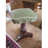 An early Victorian rosewood piano stool, the adjustable square seat on a lotus carved stem and