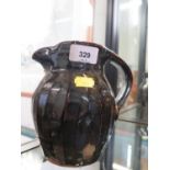 A Trevor Corser jug, with ribbed sides and brown glaze, Leach Pottery and personal stamps, 17 cm