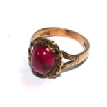 A 9 carat gold ring set with a red cabochon stone