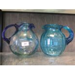 A vintage Murano clear art glass pitcher with swirl blue decoration together with another in plain