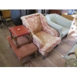 A late Victorian upholstered armchair, with downswept arms on ring turned legs and pot castors,