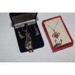 A silver cat pendant necklace with matching cat earrings together with an articulated mouse