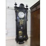 An ebonised Vienna type wall clock, with enamelled dial (cracked), the twin train movement