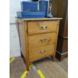 A pine bedside cabinet, with three drawers on square feet, 60 cm wide