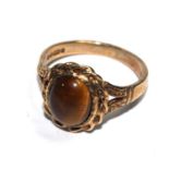 A 9 carat gold ring set with a cabochon tigers eye