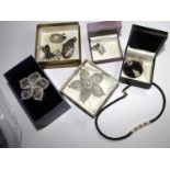 A bag containing necklaces, a bangle, brooches and pendants with mother of pearl, some silver