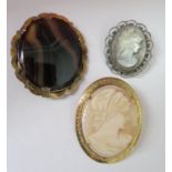A bag with two cameo brooches and another