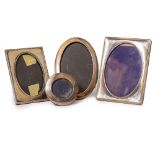 FOUR VINTAGE SILVER PHOTOFRAMES to include two circular examples and two rectangular examples, the