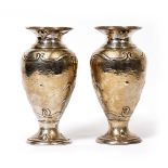 A PAIR OF EDWARDIAN ART NOUVEAU SILVER BALUSTER VASES with stylized tulip designs to the hammered