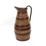 AN ANTIQUE COOPERED COPPER AND OAK SIDED JUG with looping handle, 64cm high