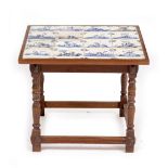 AN OAK LOW OCCASIONAL TABLE the top inset with sixteen antique Delft blue and white tiles, 55cm x
