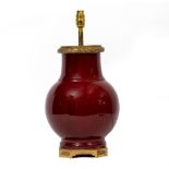 SANG DE BOEUF GLAZED TABLE LAMP with gilt metal mounts, 23cm wide x 45cm high