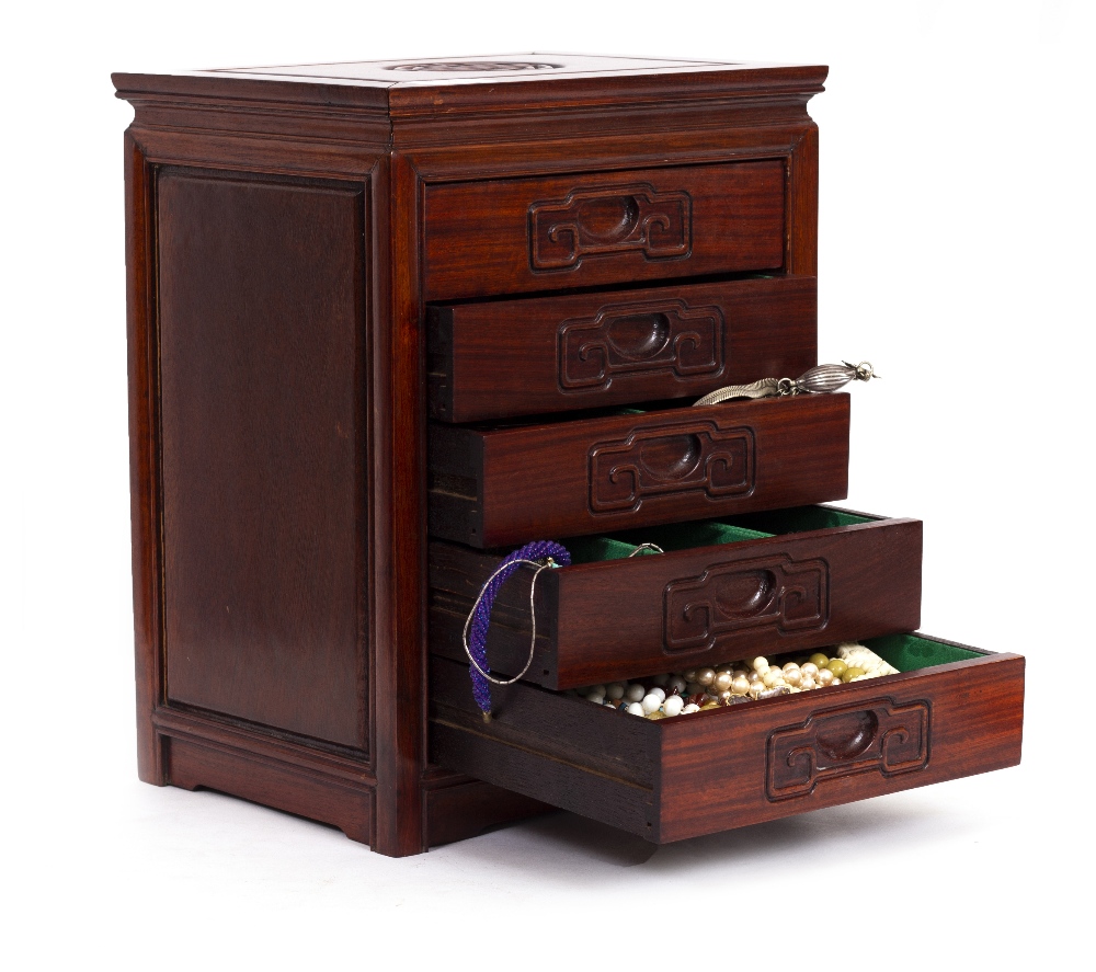 A SMALL WOODEN TABLE TOP CHEST OF FIVE DRAWERS containing various silver and jewellery, the chest
