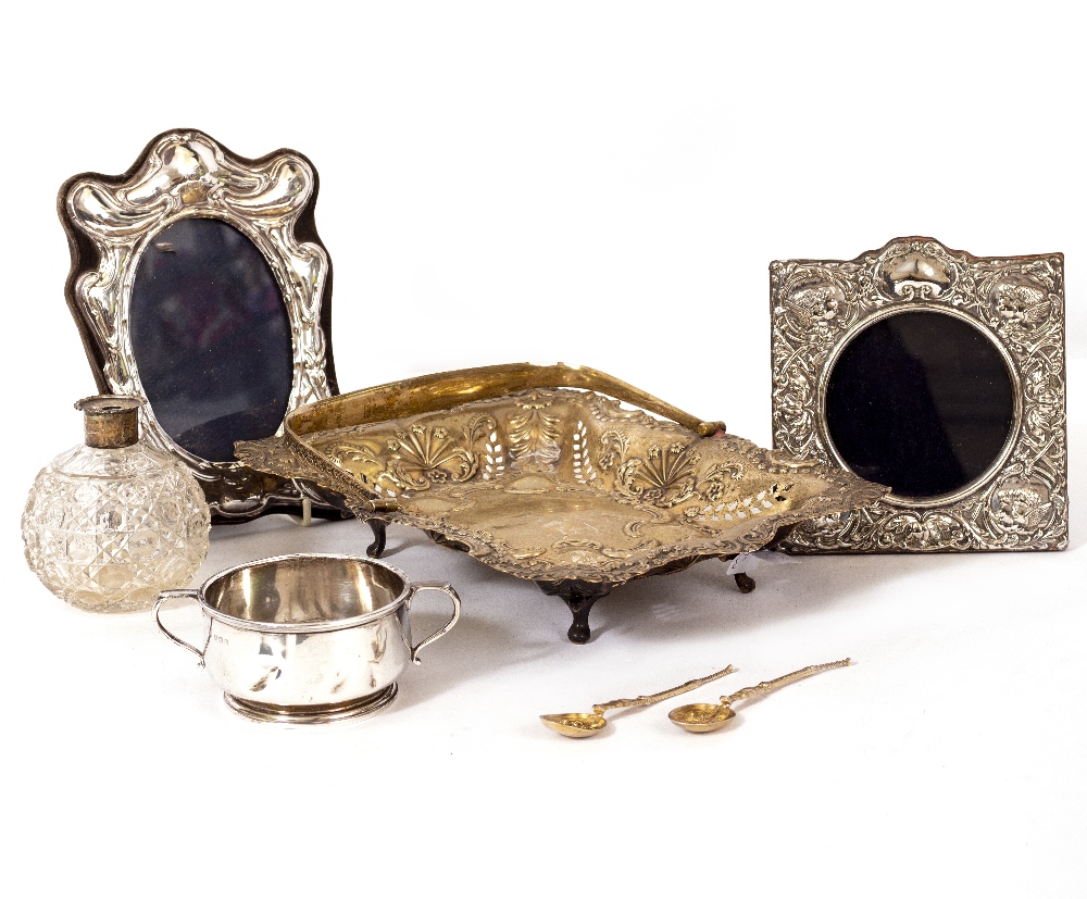 A SILVER RECTANGULAR PIERCED BASKET with looping handle, two silver mounted photograph frames, a two