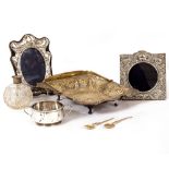 A SILVER RECTANGULAR PIERCED BASKET with looping handle, two silver mounted photograph frames, a two