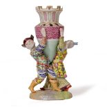 A MEISSEN PORCELAIN VASE in the form of figures holding a crenulated vessel aloft, with cross swords