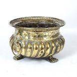 A 19TH CENTURY BRASS JARDINIERE with lion ring handles and paw feet