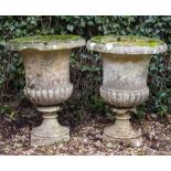 A PAIR OF RECONSTITUTED STONE GARDEN URNS of classical campana form, with lobed bodies, each 51cm