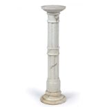 A TURNED ALABASTER TORCHIERE OR SCULPTURE STAND in the form of a fluted column, 25.5cm diameter x