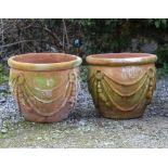A PAIR OF TERRACOTTA GARDEN PLANTERS decorated with tassels and cord swags, each approximately