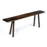 AN ANTIQUE RUSTIC OAK PIG BENCH with rectangular top and splaying legs, 138cm long x 20cm deep x