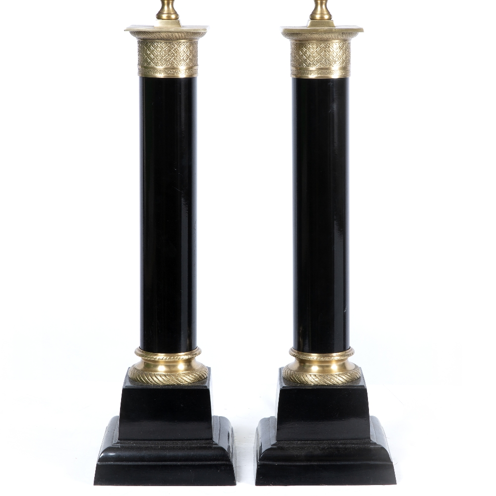 A PAIR OF EMPIRE STYLE BLACK PAINTED TABLE LAMPS in the form of cylindrical columns on square bases,