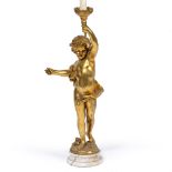 A GILT TABLE LAMP in the form of a child holding a torchiere aloft, mounted on a turned alabaster