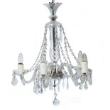 A CUT GLASS ELECTROLIER OR CHANDELIER with five scrolling branches, central baluster stem and with