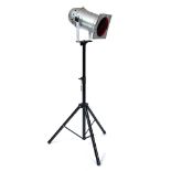 A CHROME THEATRE OR STUDIO LIGHT with a red filter and mounted on an adjustable stand