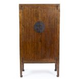 AN ORIENTAL ELM TWO DOOR CUPBOARD with circular metal lock plate and standing on stile feet, 99cm