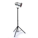 A CHROME THEATRE OR STUDIO LIGHT with a red filter and mounted on an adjustable stand, the light