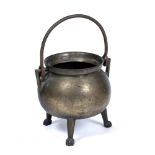 AN ANTIQUE POSSIBLY 17TH CENTURY BRONZE CAULDRON of spherical form standing on three legs and with