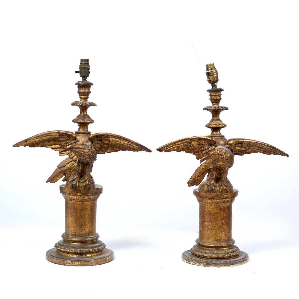 TWO SIMILAR CARVED GILTWOOD TABLE LAMPS each decorated with an eagle with spreading wings on a