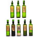 A SET OF EIGHT GREEN GLASS PHARMACISTS POISON BOTTLES with glass stoppers and paper labels, the