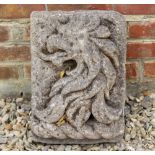 AN ANTIQUE CARVED STONE PLAQUE with a dragons head relief, 31cm wide x 41cm in height x 19cm deep