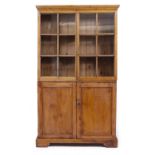 AN ANTIQUE PINE KITCHEN CABINET with two shelves and glazed doors over two panelled doors