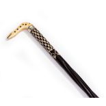 AN ANGLO INDIAN EBONY AND BONE HANDLED WALKING STICK shaped as the head of a snake with a twisted