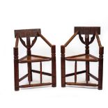 A PAIR OF 19TH CENTURY OAK TURNERS CHAIRS with carved cresting rails, triangular panelled seats