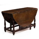 AN 18TH CENTURY AND LATER OAK OVAL GATELEG TABLE with turned legs and stretchers and drawers to