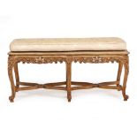 A CONTINENTAL BEECHWOOD 18TH CENTURY STYLE STOOL OR WINDOW SEAT of serpentine form with squab