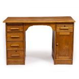 AN OAK PEDESTAL DESK the plain top above a slide and four drawers to the left, a drawer and later