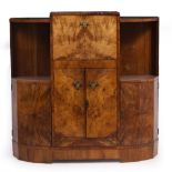 AN ART DECO BURR WALNUT VENEERED BOW FRONTED DRINKS CABINET with hinged fall front and combined