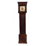 AN EIGHT DAY LONG CASE CLOCK the oak case with later chip carved decoration, the brass dial with