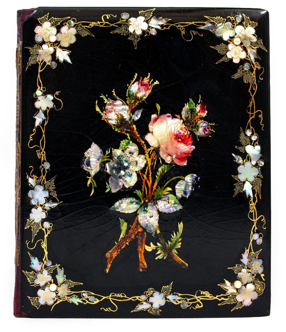 A VICTORIAN PAPIER MACHE BOUND ALBUM the cover decorated with mother of pearl and flowers, the album