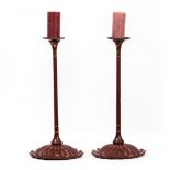 A PAIR OF JAPANESE OXBLOOD RED LACQUERED CANDLESTICKS with delicate turned stems and lotus flower