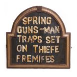 A WOODEN PAINTED POACHERS WARNING SIGN that reads 'SPRING GUNS AND MAN TRAPS SET ON THIEFE